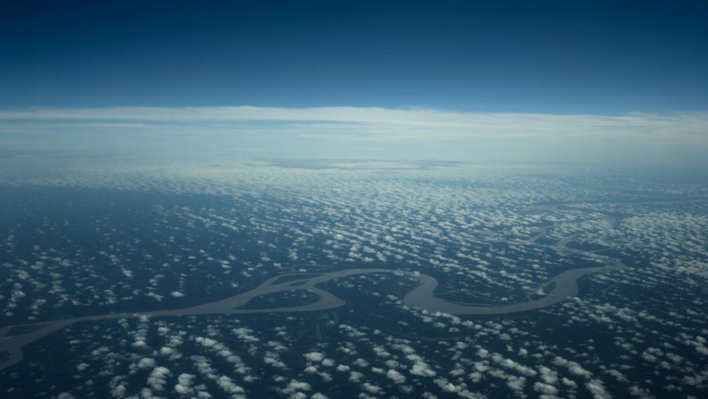 Aerial shot of the Amazon River meandering through lush forests in Brasil.