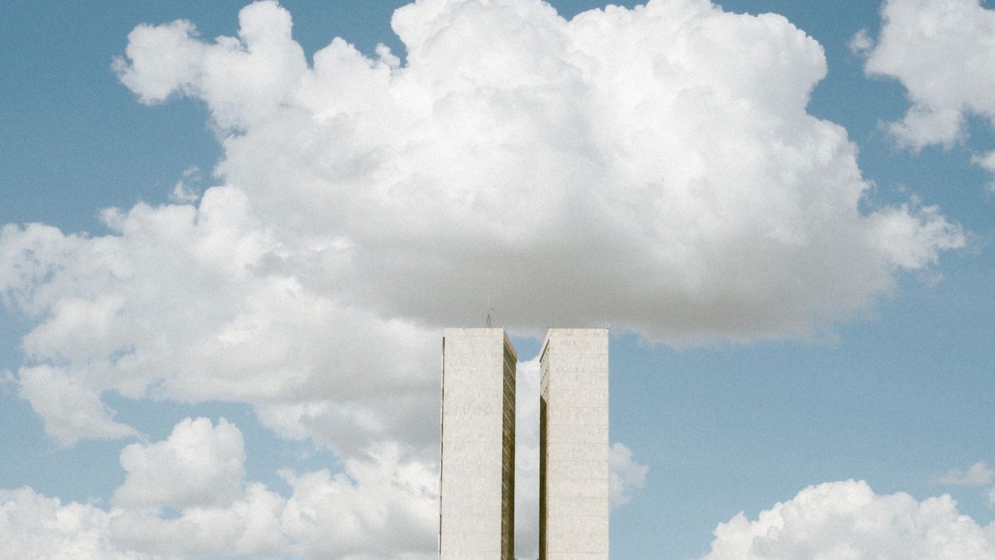 View of the National Congress in Brasília with impressive cloud formations in the sky.